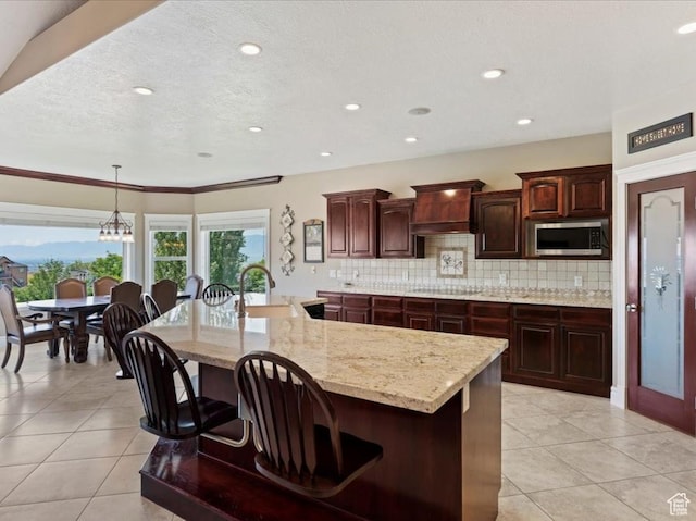 898 E 260 N, Hyde Park, UT 84318 - kitchen with dark brown cabinetry, sink, backsplash, a spacious island, and custom range hood