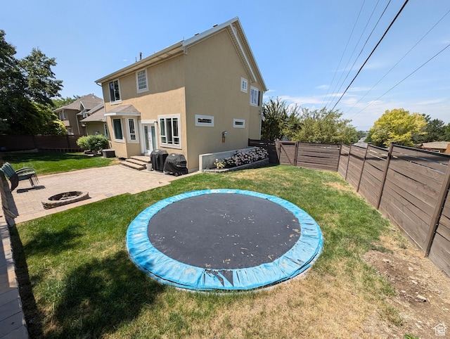 812 N Hillsdale Ln, Provo, UT 84606 - back of property with a trampoline, a lawn, a fire pit, and a patio