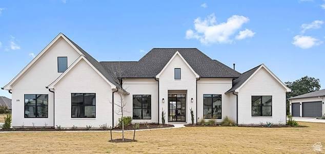 modern farmhouse with a front yard and a garage