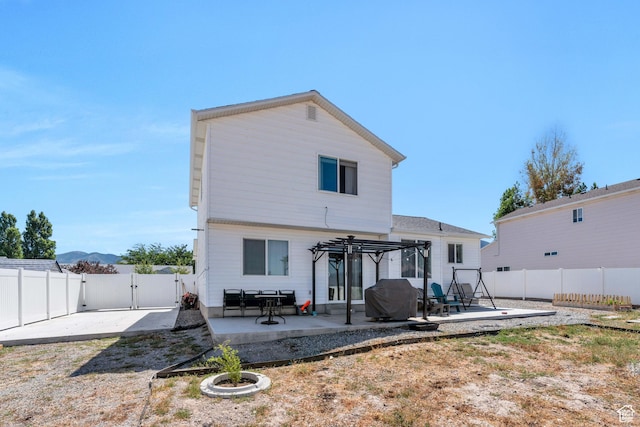 rear view of property with a pergola and a patio area