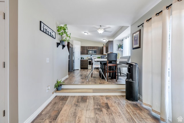 interior space featuring ceiling fan, lofted ceiling, and light wood-type flooring