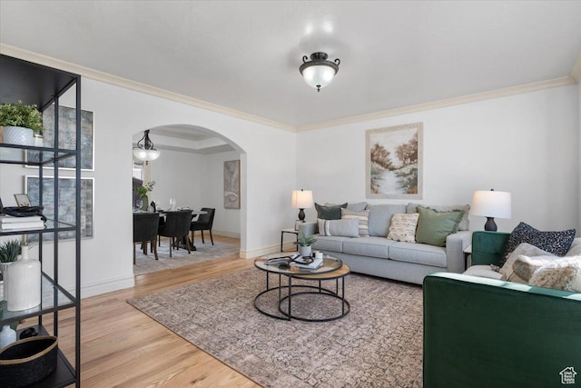 living room with baseboards, wood finished floors, arched walkways, and ornamental molding