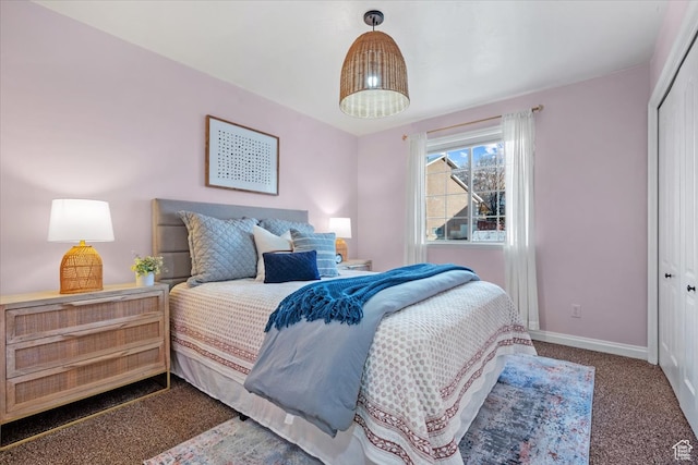 carpeted bedroom with a closet and baseboards