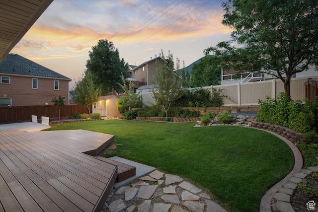 yard at dusk with a fenced backyard and a wooden deck
