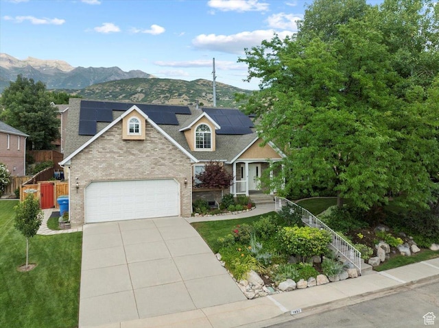 view of front of property with brick siding, driveway, a front yard, and fence