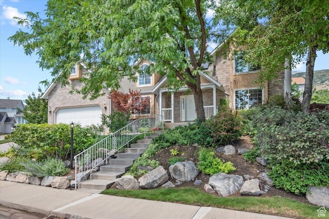 view of front of home with stairway, covered porch, and brick siding