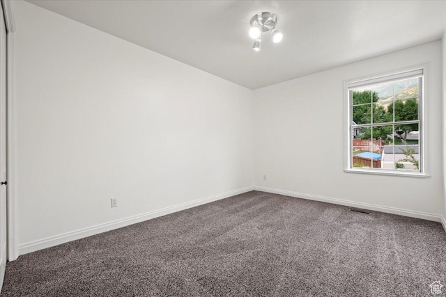 unfurnished room with carpet flooring and baseboards