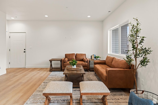 living room featuring baseboards, light wood-type flooring, visible vents, and recessed lighting