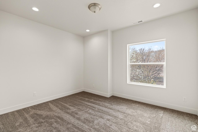 unfurnished room featuring recessed lighting, baseboards, dark carpet, and visible vents