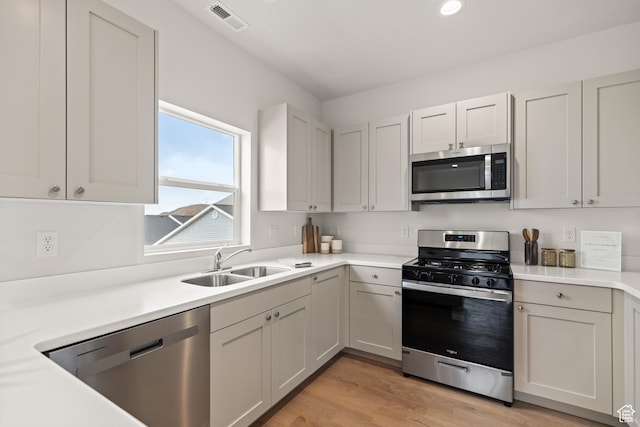 kitchen with light countertops, a sink, appliances with stainless steel finishes, and visible vents