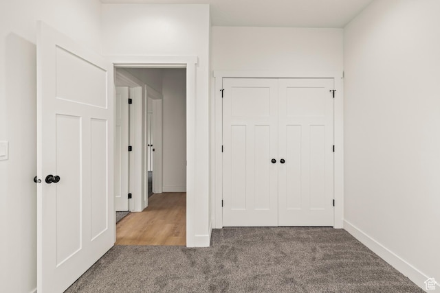 unfurnished bedroom featuring carpet flooring, baseboards, and a closet