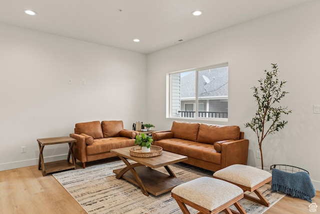 living area with baseboards, visible vents, light wood-style floors, and recessed lighting