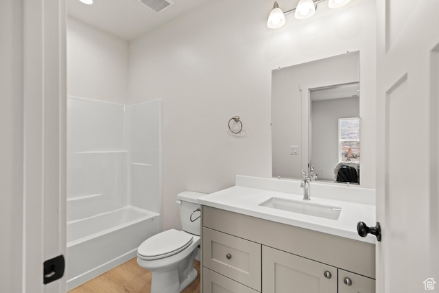 bathroom featuring toilet, vanity, wood finished floors, ensuite bath, and visible vents