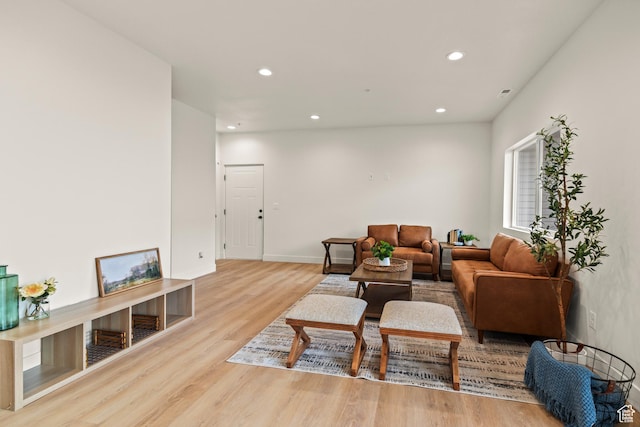 living room with baseboards, wood finished floors, and recessed lighting