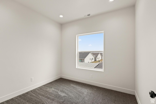spare room featuring baseboards, visible vents, dark colored carpet, and recessed lighting