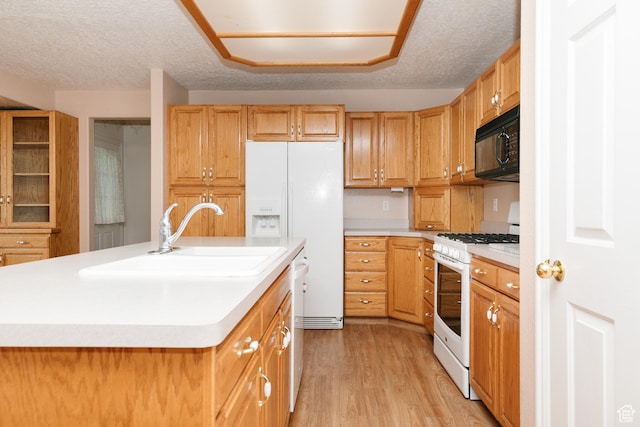 596 Eagle Dr, Preston, ID 83263 - kitchen with white appliances, sink, a kitchen island with sink, and light hardwood / wood-style flooring