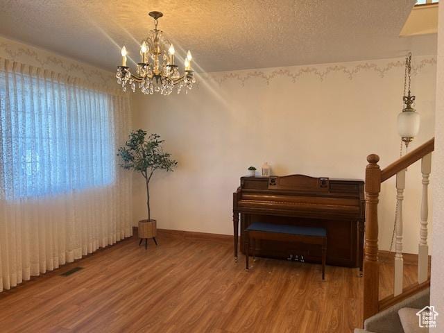 596 Eagle Dr, Preston, ID 83263 - miscellaneous room with wood-type flooring, a chandelier, and a textured ceiling