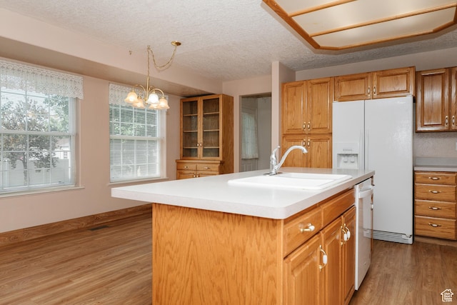 596 Eagle Dr, Preston, ID 83263 - kitchen with sink, light wood-type flooring, hanging light fixtures, a kitchen island with sink, and a textured ceiling
