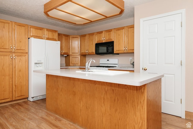 596 Eagle Dr, Preston, ID 83263 - kitchen featuring sink, a textured ceiling, a center island with sink, light wood-type flooring, and white appliances