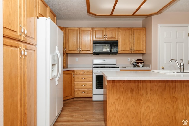 596 Eagle Dr, Preston, ID 83263 - kitchen featuring light wood-type flooring, a textured ceiling, white appliances, and kitchen peninsula