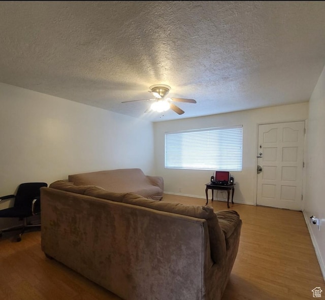 246 E Helm Ave S Unit 26, South Salt Lake, UT 84115 - living room featuring light wood-style flooring, ceiling fan, baseboards, and a textured ceiling