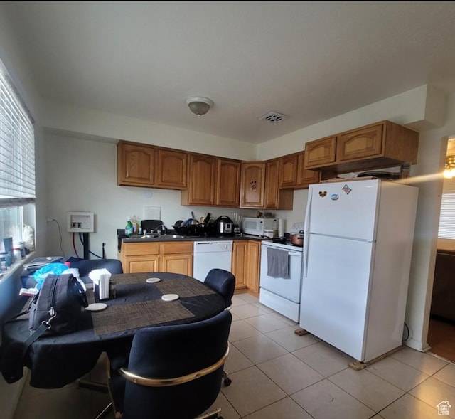 246 E Helm Ave S Unit 26, South Salt Lake, UT 84115 - kitchen featuring white appliances, dark countertops, light tile patterned floors, brown cabinets, and a sink