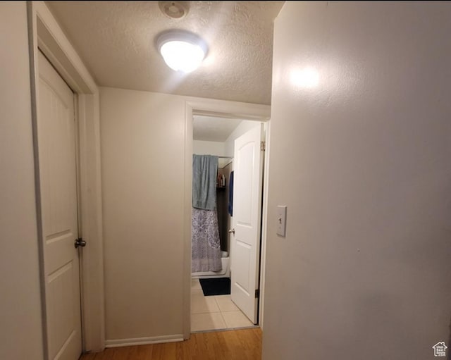 246 E Helm Ave S Unit 26, South Salt Lake, UT 84115 - corridor featuring light wood-style flooring, a textured ceiling, and baseboards