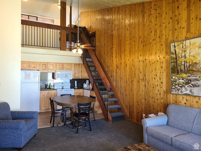 2176 S Bear Lake Blvd S Unit 452, Garden City, UT 84028 - living area with stairs, wooden walls, a high ceiling, and dark carpet