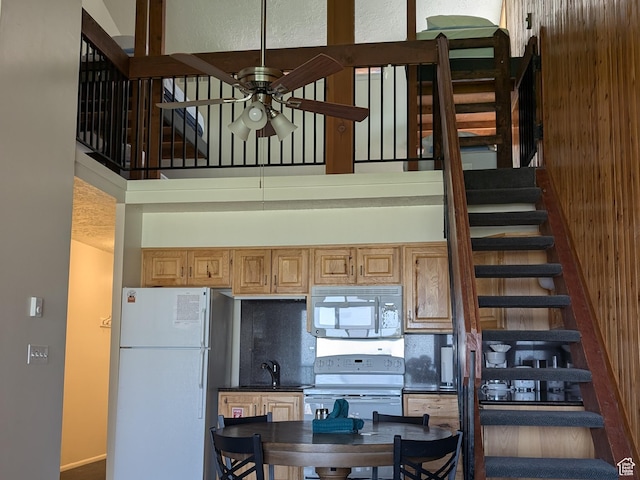 2176 S Bear Lake Blvd S Unit 452, Garden City, UT 84028 - kitchen featuring dark countertops, white appliances, a sink, and a towering ceiling