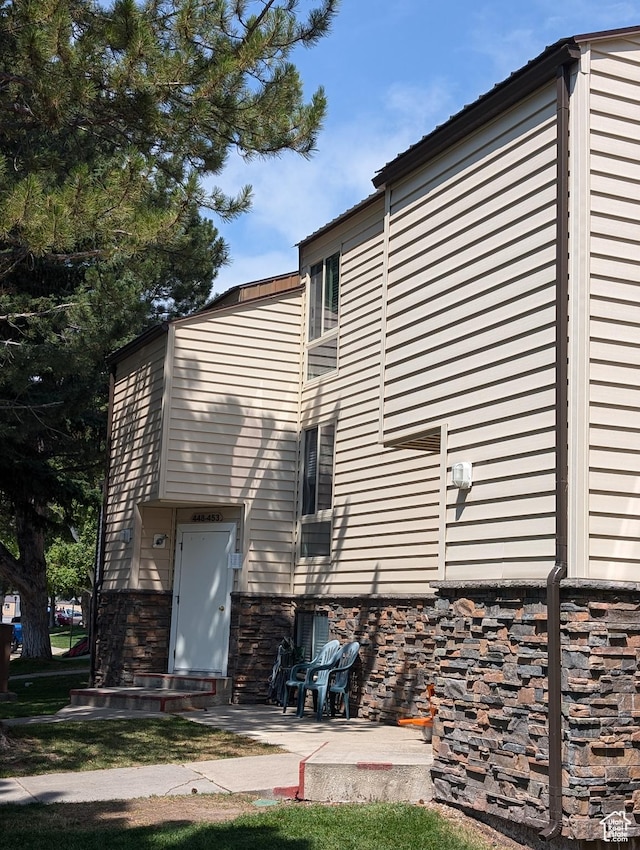 2176 S Bear Lake Blvd S Unit 452, Garden City, UT 84028 - rear view of house featuring entry steps, stone siding, and a patio area