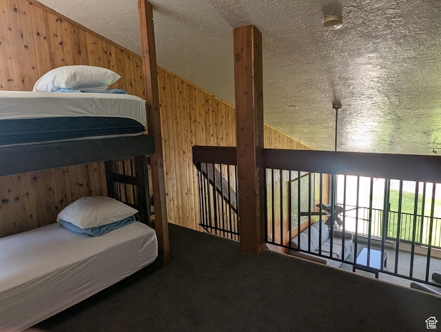 2176 S Bear Lake Blvd S Unit 452, Garden City, UT 84028 - carpeted bedroom with vaulted ceiling, wood walls, and a textured ceiling