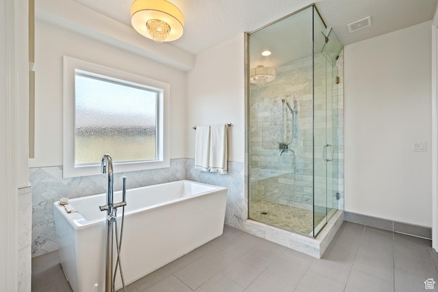 6026 S Zen Trail Way, St George, UT 84790 - bathroom featuring plus walk in shower, tile walls, and tile patterned floors