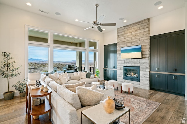 6026 S Zen Trail Way, St George, UT 84790 - living room featuring hardwood / wood-style flooring, a mountain view, a towering ceiling, and a fireplace