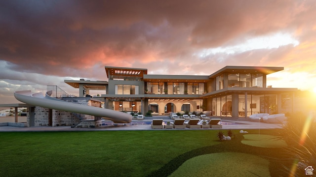 1272 N Hillside Way, Santa Clara, UT 84765 - back house at dusk featuring a patio, a balcony, and a lawn