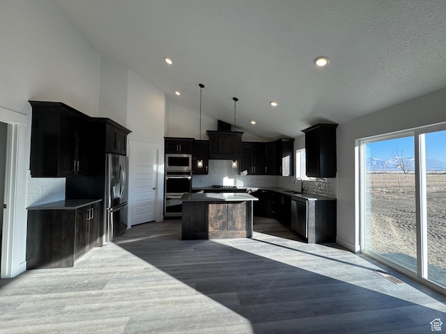 426 E Redwood Ln Unit 119, Grantsville, UT 84029 - kitchen featuring appliances with stainless steel finishes, a kitchen island, tasteful backsplash, dark cabinetry, and recessed lighting
