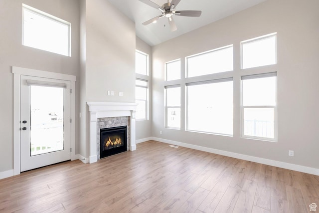 9829 N Aaron Ave Unit 213, Eagle Mountain, UT 84005 - unfurnished living room with ceiling fan, a stone fireplace, high vaulted ceiling, and light hardwood / wood-style floors