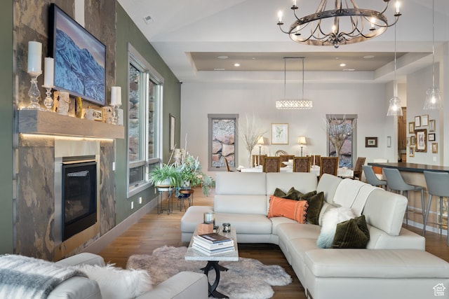 1310 Mellow Rd, Park City, UT 84060 - living area with an inviting chandelier, a glass covered fireplace, visible vents, wood finished floors, and a raised ceiling