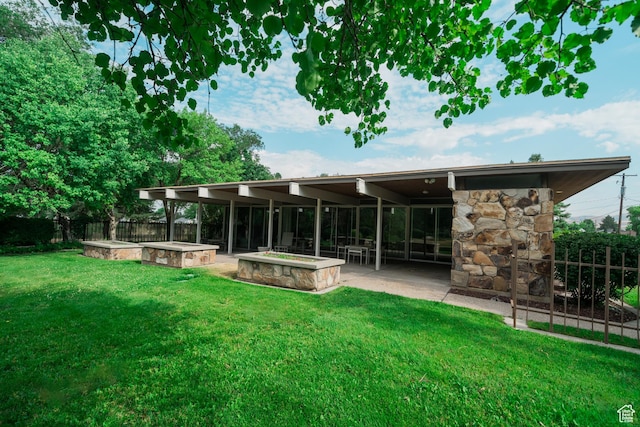 975 N 1600 E, Logan, UT 84321 - back of house featuring stone siding, fence, a patio, a jacuzzi, and a yard