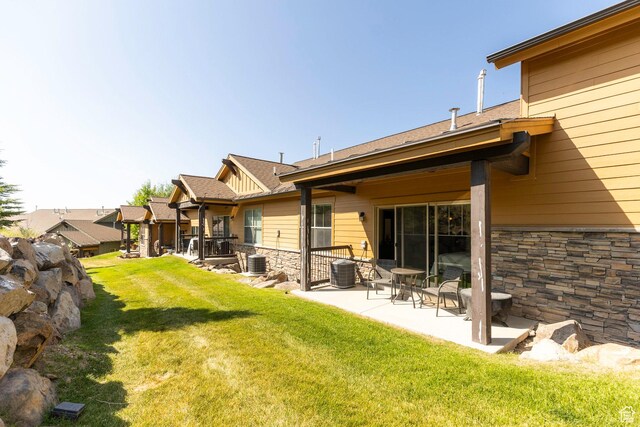 14160 N Council Fire Trl, Heber City, UT 84032 - rear view of house featuring stone siding, a yard, a patio, and central air condition unit
