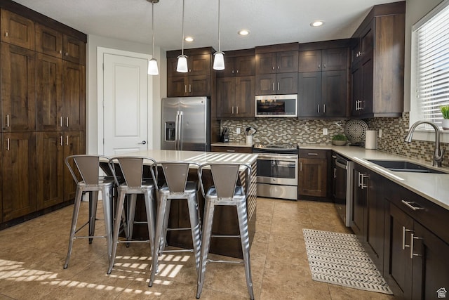 635 W 0470 N, Moab, UT 84532 - kitchen featuring backsplash, a center island, a kitchen bar, sink, and appliances with stainless steel finishes