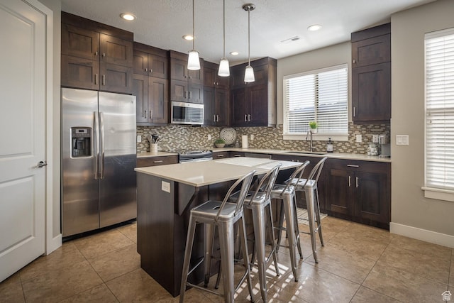 635 W 0470 N, Moab, UT 84532 - kitchen featuring appliances with stainless steel finishes, a kitchen breakfast bar, hanging light fixtures, a kitchen island, and sink