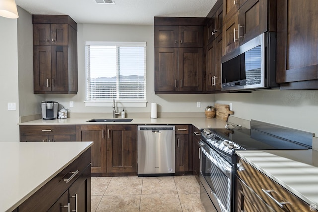 631 W 470 N, Moab, UT 84532 - kitchen featuring light tile patterned floors, appliances with stainless steel finishes, dark brown cabinetry, and sink