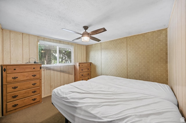 carpeted bedroom featuring ceiling fan and a textured ceiling