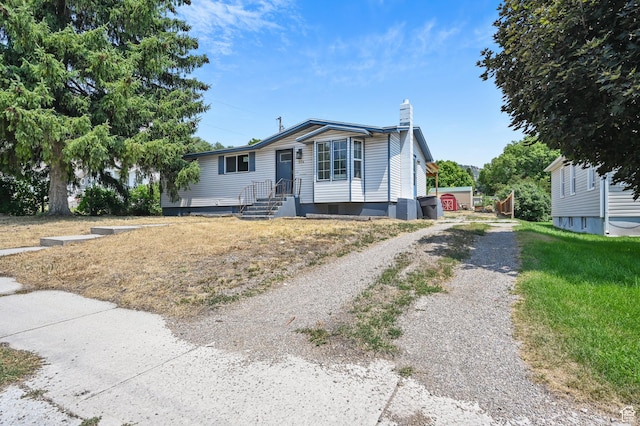view of front facade featuring driveway and a chimney