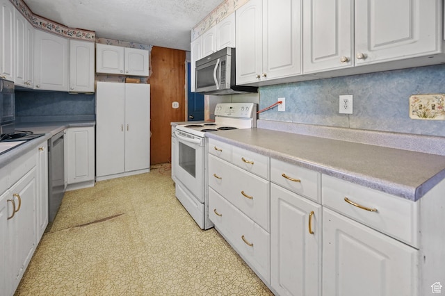 kitchen with a textured ceiling, white cabinets, light countertops, light floors, and appliances with stainless steel finishes