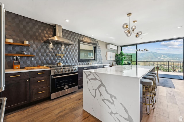 6387 Silver Sage Dr, Park City, UT 84098 - kitchen with a center island, a wall unit AC, expansive windows, high end stove, and wall chimney range hood