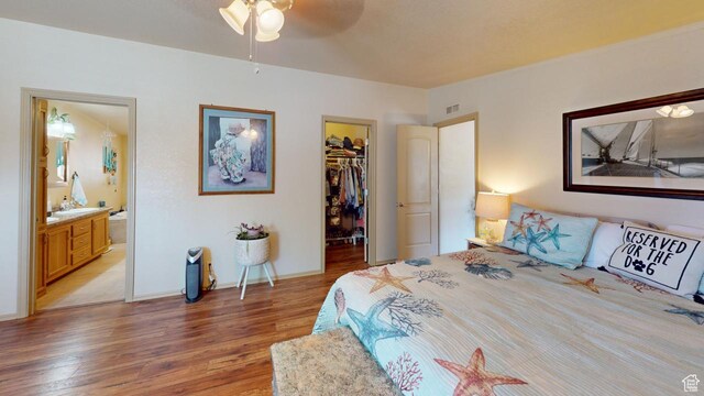 990 S Freedom Way, Big Water, UT 84741 - bedroom with a spacious closet, ceiling fan, light hardwood / wood-style floors, ensuite bath, and a closet