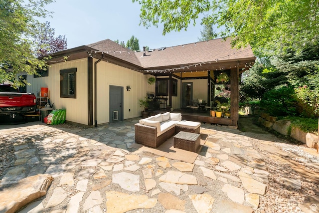 back of house featuring a patio area, an outdoor living space, and roof with shingles