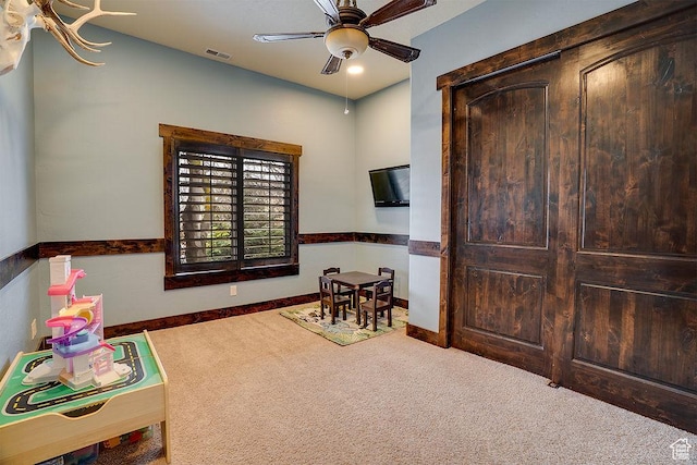 rec room with baseboards, carpet floors, visible vents, and a ceiling fan
