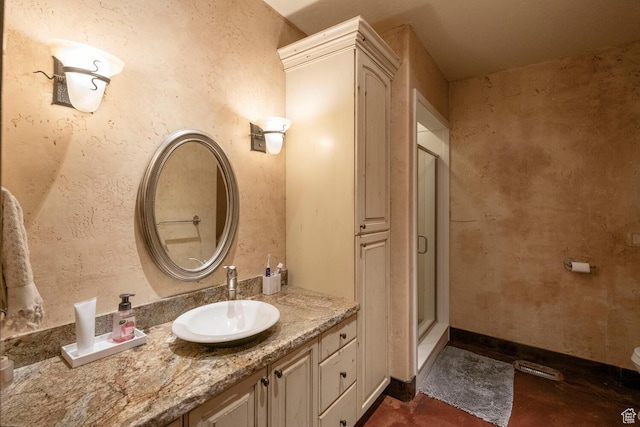full bathroom featuring a stall shower, vanity, and baseboards